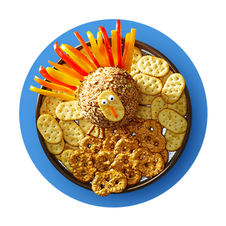 Holiday Cheese Ball decorated to look like a turkey surrounded by crackers and pretzel thins. 