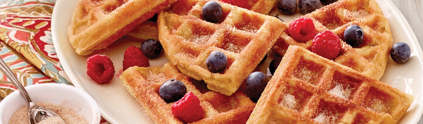 Platter of waffled churros with blueberries and raspberries.