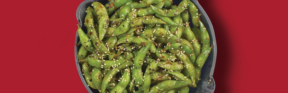 garlic flavored edamame in cast iron skillet