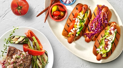Gourmet steak and hot dogs with vegetable toppings.