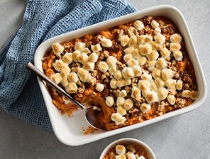 Dish of warm sweet potato casserole topped with toasted mini marshmallows.