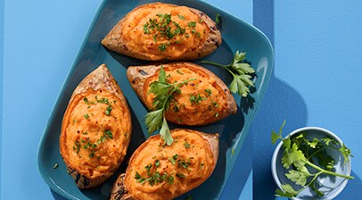 Plated Sweet Potatoes filled with creamy sweet potato and ricotta cheese garnished with parsley.